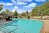 Inviting outdoor pool area with stylish lounge chairs and lush greenery, perfect for relaxation and enjoyment.