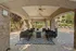 Inviting outdoor patio with stylish seating under an elegant arched ceiling, surrounded by lush greenery and peaceful surroundings.