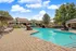 Charming community pool with elegant lounge chairs, surrounded by lush greenery and modern architecture, perfect for relaxation and leisure.