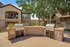 Inviting outdoor setup with modern dual grilling stations, surrounded by lush greenery and attractive apartment buildings.