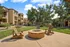Inviting outdoor space featuring cozy fire pit surrounded by comfortable seating in a sunlit apartment community with lush greenery.