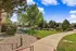Beautiful landscaped apartment community featuring a lush green garden, pathway, and inviting shared pool area.