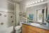 Bright and inviting bathroom with elegant vanity, stylish decor, and a glimpse into a sunlit dining area.