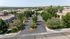 Aerial view of a serene residential community with charming homes, lush greenery, and well-maintained roads, perfect for tranquil living.