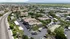 Scenic aerial view of a charming residential community with lush greenery and ample parking, offering a peaceful suburban lifestyle.