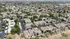 Aerial view of a modern residential complex surrounded by lush greenery, showcasing an inviting community in a serene desert landscape.
