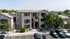 Charming apartment exterior with well-maintained landscaping, stylish architecture, and ample parking space.