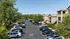 Charming apartment complex with lush trees and ample parking, offering a serene suburban living experience.
