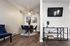Modern dining space with elegant blue chairs, stylish art, and wall-mounted TV in a cozy living room.