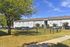 Charming apartment building surrounded by lush greenery and ample parking space.