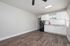 Stylish and modern kitchen with dark wood flooring, white cabinets, and sleek black appliances.