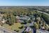 Aerial view of a peaceful suburban area with a cluster of buildings surrounded by lush greenery.
