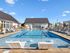Luxurious resort-style community pool with elegant lounge chairs and spacious sunlit pool deck.