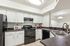 Modern kitchen with sleek black appliances, elegant countertops, and bright white cabinetry, complete with a dual sink and stylish lighting.
