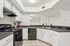 Modern kitchen with sleek black appliances, ample counter space, and stylish white cabinetry. Bright and inviting layout perfect for culinary enthusiasts.