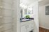 Bright and modern bathroom with sleek vanity, ample shelving, and elegant lighting, ideal for a stylish home.