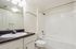 Elegant bathroom with a spacious white bathtub, modern fixtures, and a sleek countertop sink.