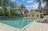 Inviting outdoor swimming pool area with sun loungers surrounded by lush palm trees and vibrant greenery.