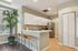 Bright and inviting kitchen with sleek white cabinets, a stylish tile backsplash, and a cozy breakfast bar with modern bar stools.