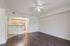 Bright and spacious living area with elegant dark wood flooring and open access to a modern kitchen.