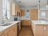 Modern kitchen with sleek wooden cabinetry, stainless steel appliances, and a spacious island, offering a bright and inviting culinary space.
