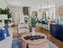 Chic and modern open-concept living space with stylish decor, featuring a cozy seating area, elegant dining setup, and a sleek kitchen with stainless steel appliances.