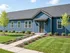 Charming blue ranch-style home with manicured lawn and inviting entryway, perfect for comfortable living.