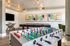 Chic entertainment room with a foosball table, pool table, and modern art decor, ideal for leisure and relaxation.