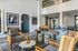 Chic and modern apartment lounge featuring elegant wicker chairs, artistic decor, and a spacious, inviting ambiance.