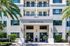 Inviting apartment leasing center with modern architecture, surrounded by lush greenery and elegant balconies.