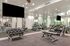 Modern fitness center featuring free weights, benches, and mirrored walls in a bright, spacious environment.