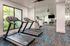 Modern fitness center with state-of-the-art treadmills, large windows offering natural light, and a spacious workout area.