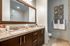 Elegant bathroom with granite double-sink vanity and chic decor, featuring modern fixtures and stylish wall art.