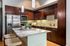 Modern kitchen featuring sleek stainless steel appliances, elegant granite countertops, and rich dark wood cabinetry, illuminated by stylish pendant lighting.