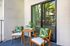 Charming outdoor balcony with cozy wooden chairs and a tropical vibe, perfect for relaxation.