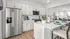 Modern kitchen with sleek stainless steel appliances, quartz countertops, and a cozy breakfast bar, perfect for stylish living.