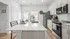 Modern kitchen featuring sleek white countertops, stainless steel appliances, and a spacious breakfast bar with stylish dining setup.