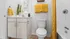 Contemporary bathroom with sleek vanity, vibrant yellow accents, and a minimalist design.