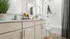 Bright and elegant bathroom featuring sleek cabinetry with sunflowers adding a vibrant touch, a spacious countertop, and a stylish bath area with modern fixtures.