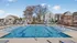 Luxurious outdoor swimming pool area with modern sun loungers and charming homes in the background, perfect for relaxation and enjoyment.