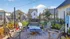 Charming outdoor patio with cozy fire pit, stylish Adirondack chairs, and vibrant landscaping in a modern townhouse community.