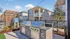 Modern outdoor bbq area with sleek grills and a charming apartment backdrop, perfect for social gatherings and relaxation.
