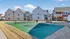 Charming residential community with modern townhouses surrounding a vibrant tennis court, perfect for active outdoor living.