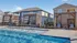 Modern poolside oasis featuring stylish cabanas and sparkling blue water, set against charming residential homes.