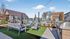 Vibrant outdoor community area featuring cozy seating, modern barbecue grills, and a sparkling pool set against a clear blue sky.
