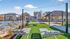 Charming outdoor community space featuring stylish lounge chairs, lush green lawns, and a sparkling pool, perfect for relaxation and enjoyment.