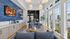 Bright modern living area with large windows, cozy blue sofas, and stylish decor, ideal for relaxation and entertainment.