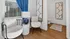 Chic apartment corner featuring plush chairs, elegant blue curtains, and modern artistic decor, perfect for relaxation.