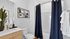 Modern bathroom with elegant navy curtains, sleek white countertops, and stylish decor accents.