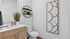 Modern bathroom with sleek wooden vanity, stylish wall art, and circular shelving with decorative accents.